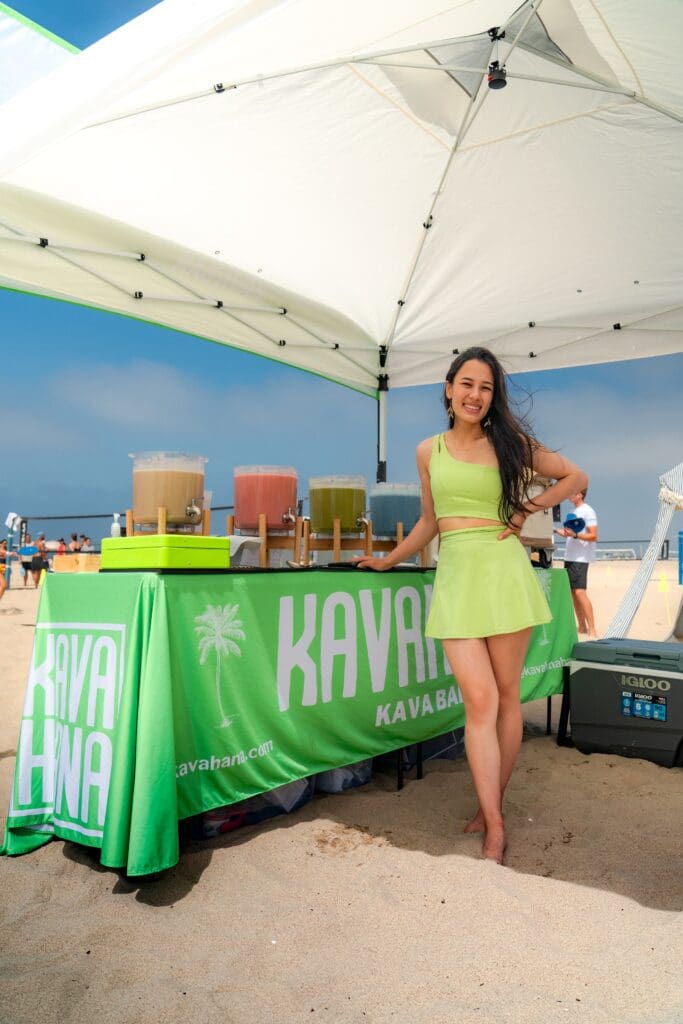 hannah from kavahana standing in front of the kavahana booth at the beach in santa monica